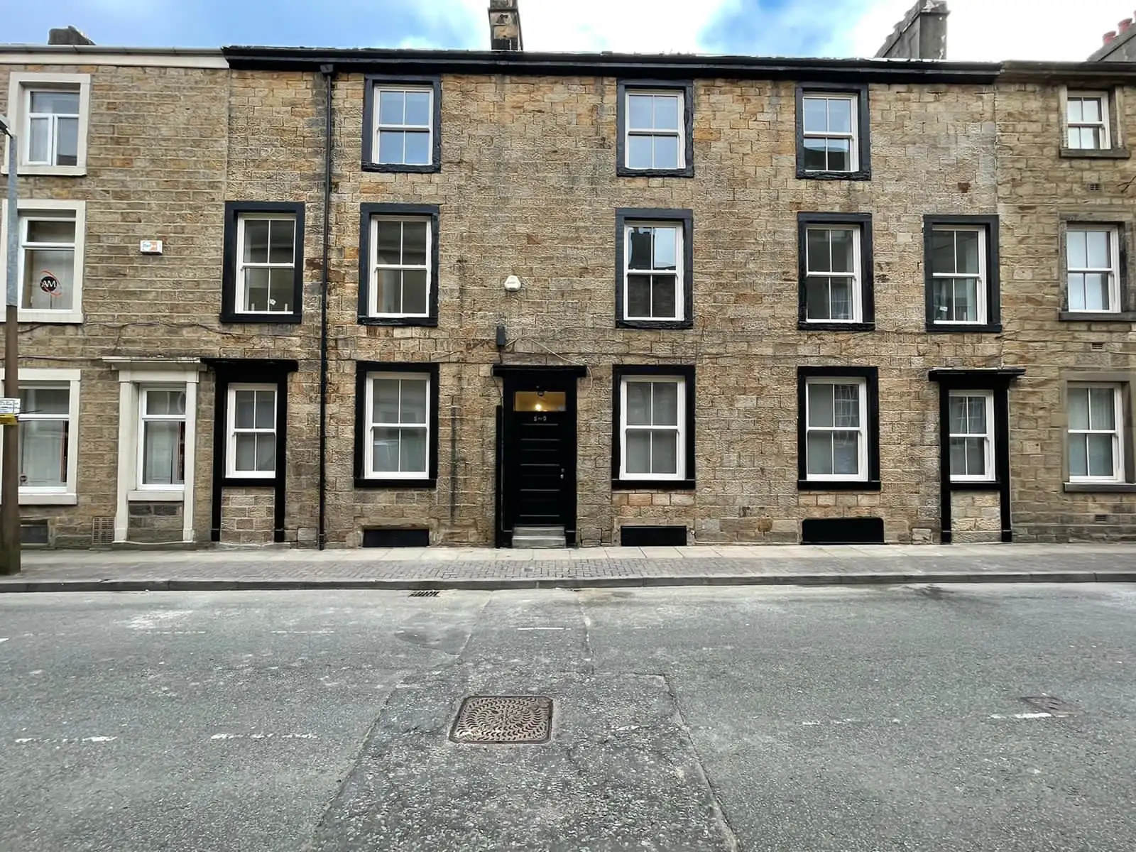 Stone terrace with sash windows, surrounds and front doors repainted in black