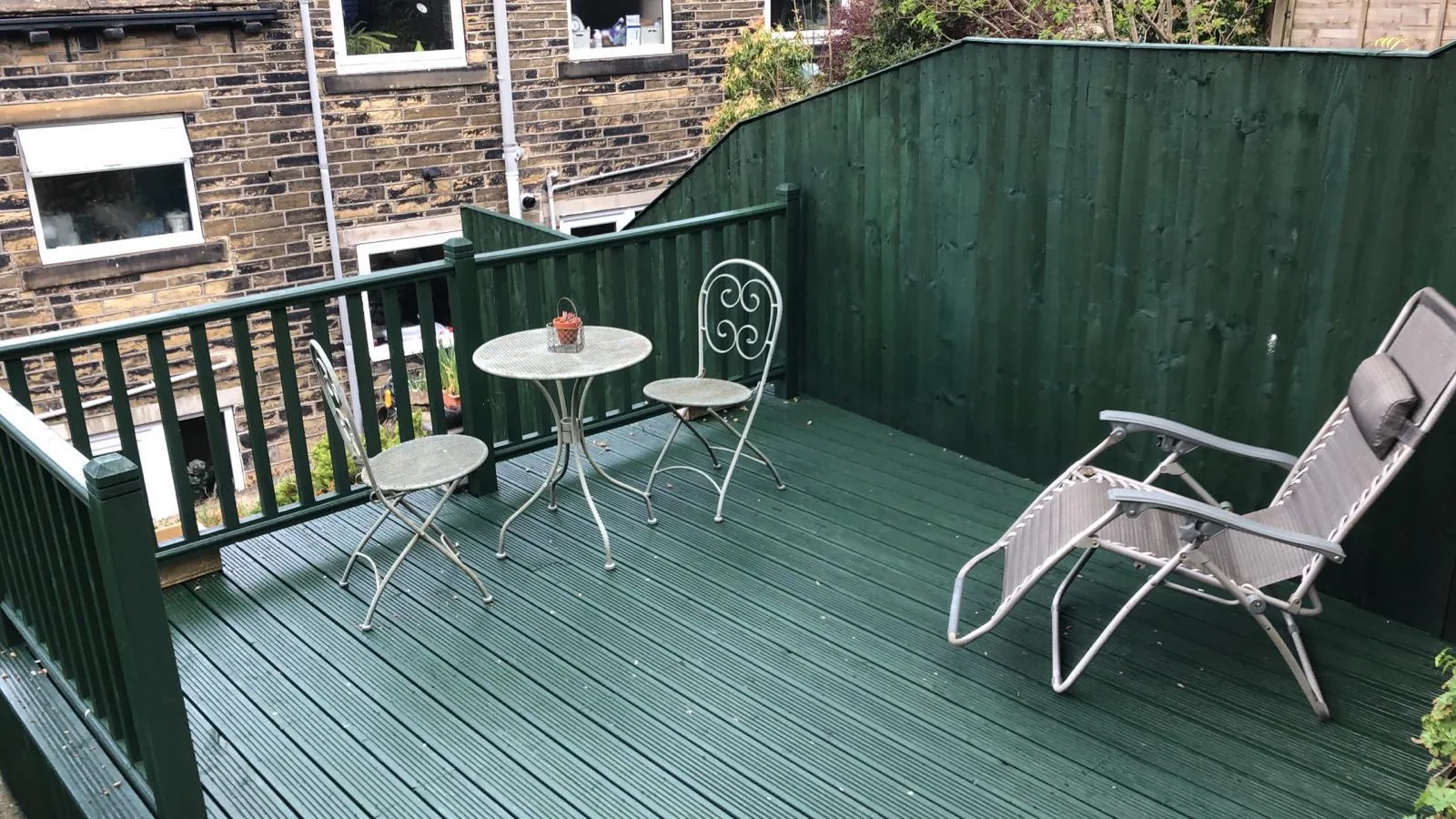 Raised garden decking, balustrade and fence panels freshly painted in deep forest green by Home Hues