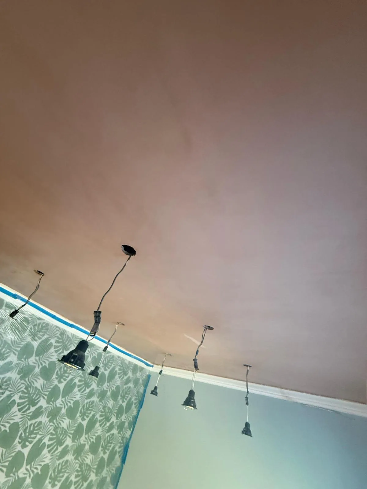 Freshly skimmed ceiling drying above a wallpapered period bedroom
